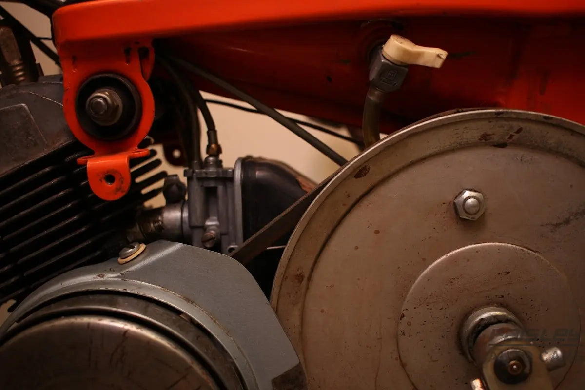 a close up of a motorcycle engine with a red handlebar