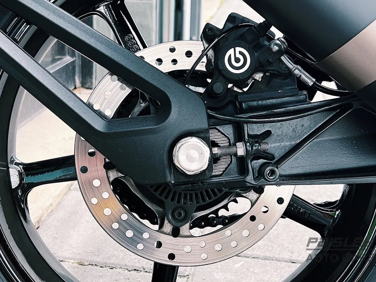 the front brake of a motorcycle parked on the side of the road