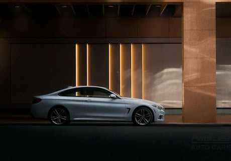 silver coupe parked beside brown wall