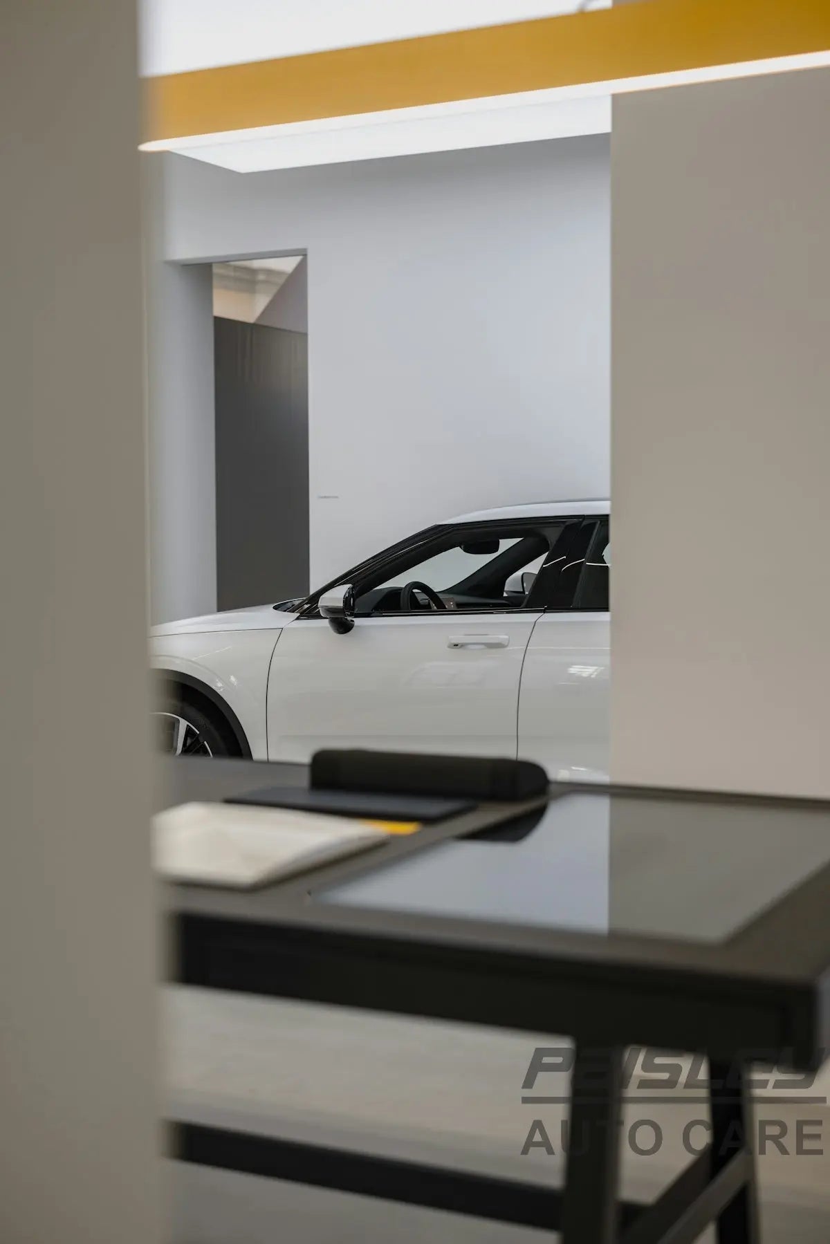 a white car is parked in a showroom