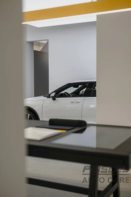 a white car is parked in a showroom